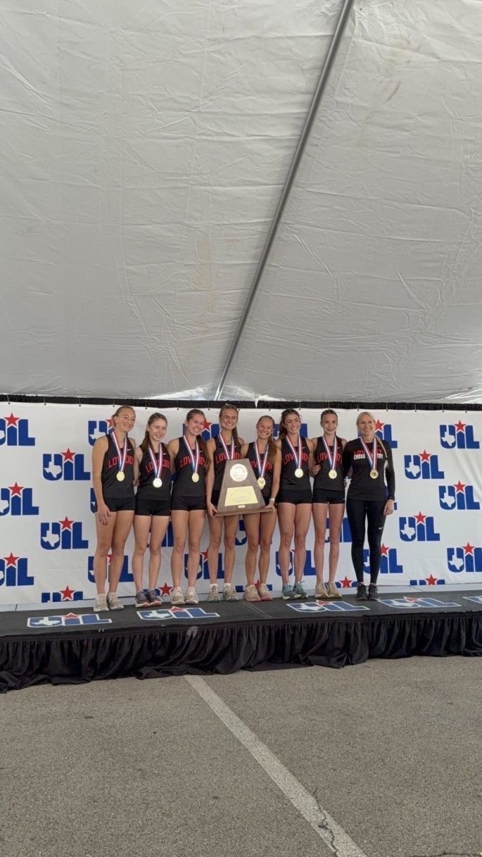 The varsity Lovejoy girls cross country team posing after winning the state meet.